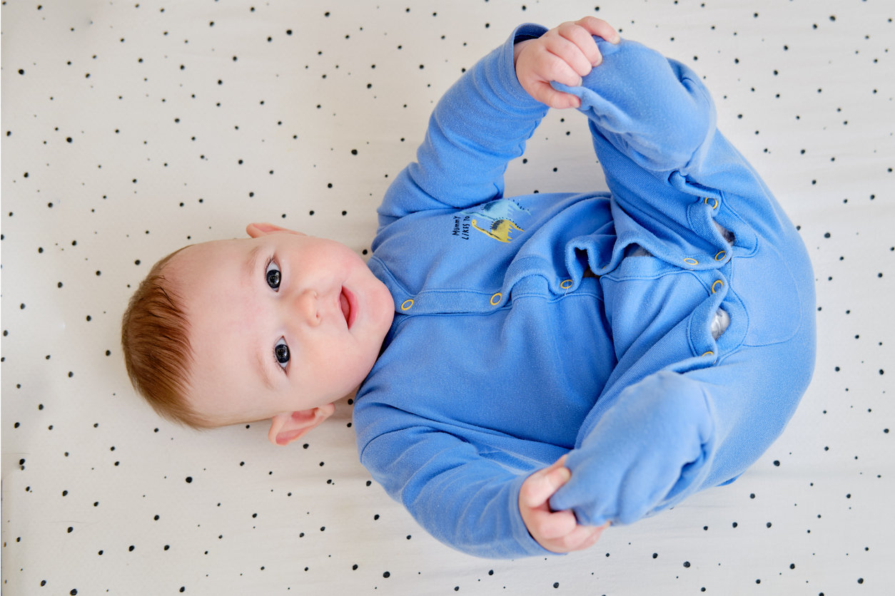 Strampler für Babys. Blauer Strampler mit Druckknöpfen auf Beininnenseite.